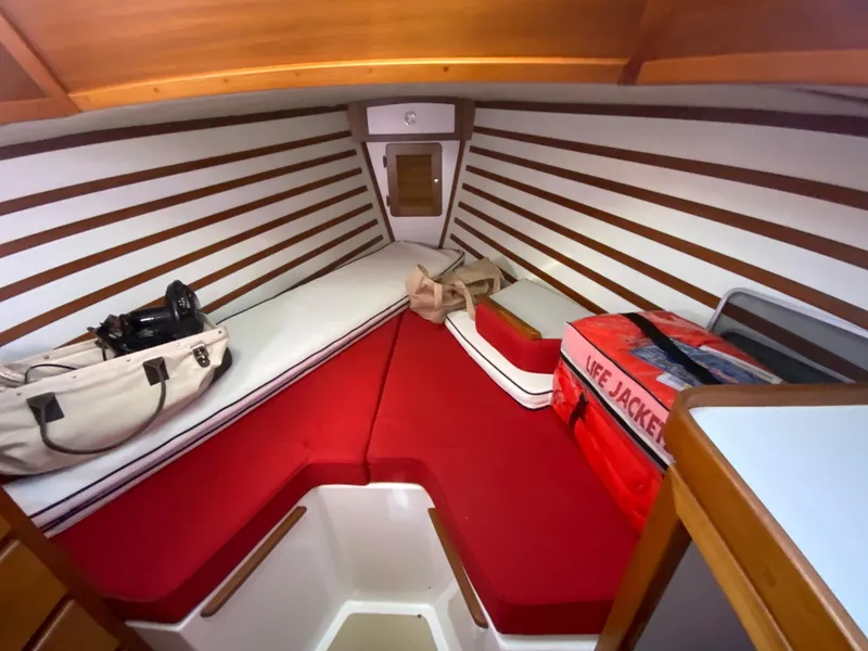 Slide: The Image of Interior cabin of 2014 Com-Pac 27 sailboat with red cushions and life jackets. - 29