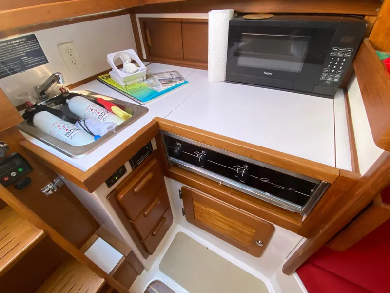 Slide: The Image of Compact galley in 2014 Com-Pac 27 sailboat with microwave, stove, and sink. - 30