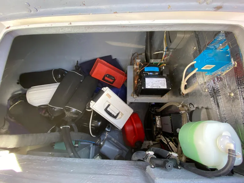Slide: The Image of Storage compartment of a 2014 Com-Pac 27 sailboat with various equipment and tools. - 33
