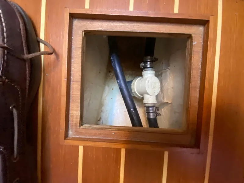 Slide: The Image of Access panel on Com-Pac 27 sailboat, showing plumbing and hoses, 2014 model. - 35