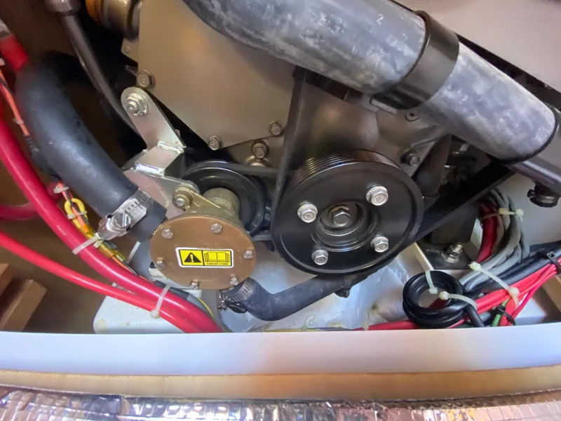 Slide: The Image of Engine compartment of a 2014 Com-Pac 27 sailboat with visible hoses and pulleys. - 37