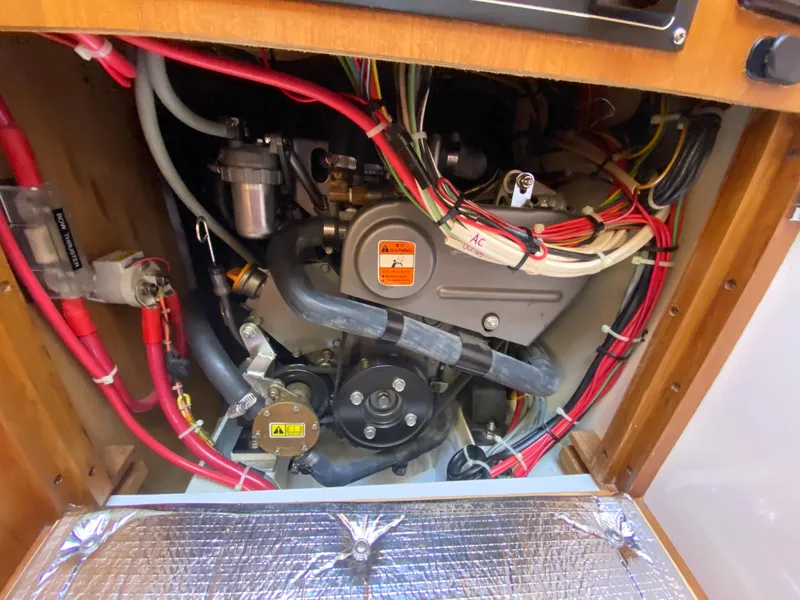 Slide: The Image of Engine compartment of a 2014 Com-Pac 27 sailboat with visible wiring and components. - 39