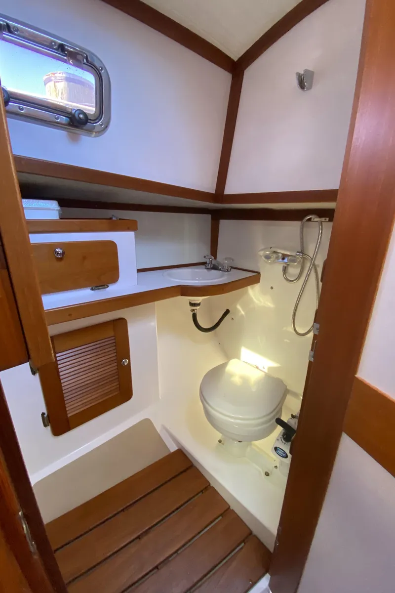 Slide: The Image of 2014 Com-Pac 27 sailboat bathroom with wooden accents and compact design. - 41