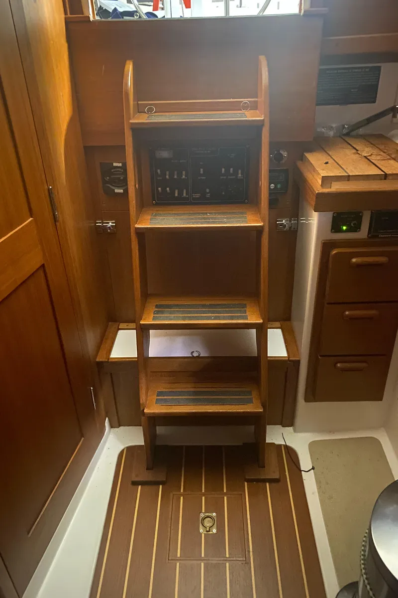 Slide: The Image of Interior of 2014 Com-Pac 27 sailboat with wooden steps and cabinetry. - 44