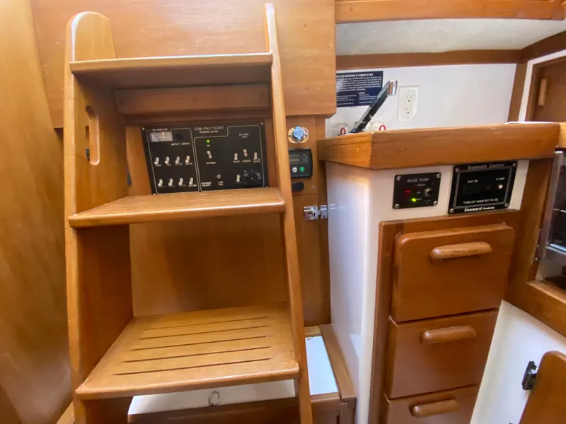 Slide: The Image of Interior of 2014 Com-Pac 27 sailboat with wooden cabinetry and control panels. - 45