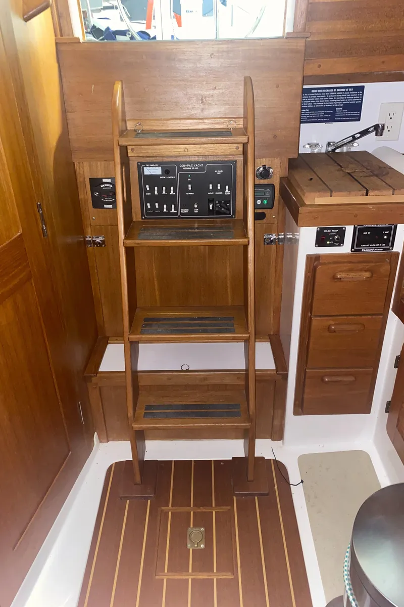 Slide: The Image of Interior of a 2014 Com-Pac 27 sailboat with wooden ladder and control panel. - 46