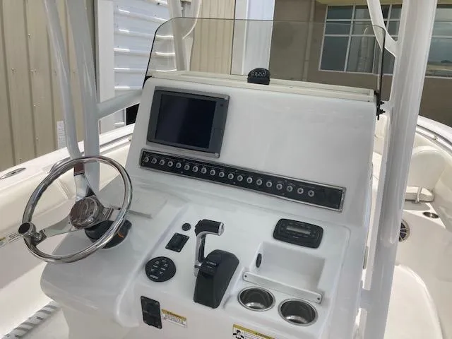 Slide: The Image of 2014 Sportsman Heritage 251 Center Console boat dashboard with steering wheel and electronic controls. - 3