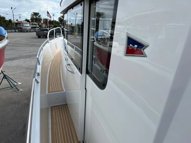Slide: The Image of 2024 Nimbus Commuter 9 #136 boat side view with deck and logo. - 12