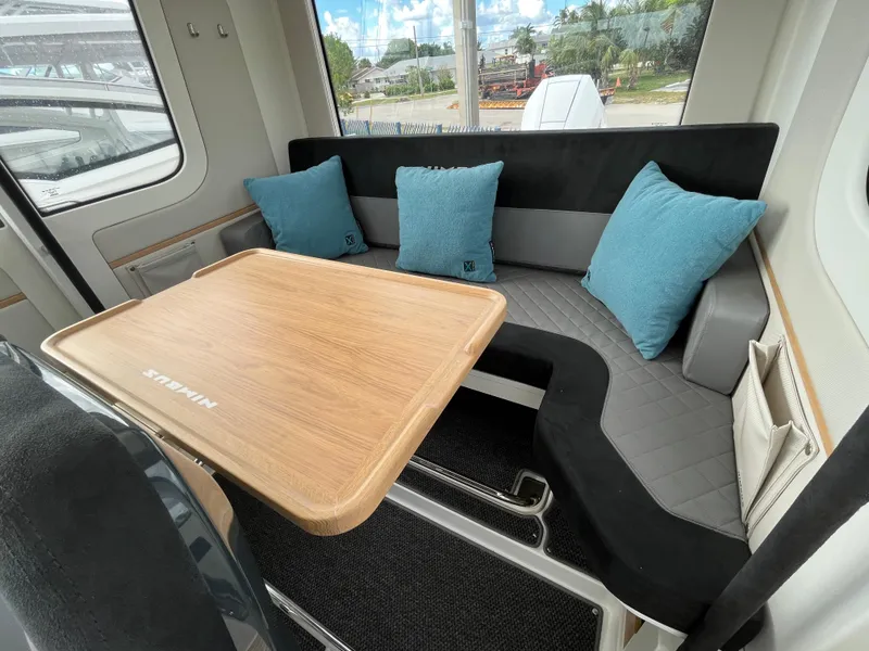 Slide: The Image of Interior seating area of 2024 Nimbus Commuter 9 #136 with wooden table and blue cushions. - 20