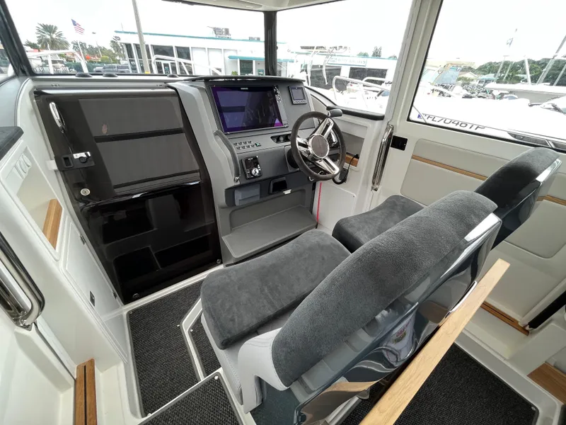 Slide: The Image of 2024 Nimbus Commuter 9 #136 boat cockpit with modern navigation system and plush seating. - 23