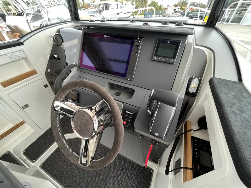 Slide: The Image of 2024 Nimbus Commuter 9 #136 boat cockpit with modern steering wheel and navigation system. - 24