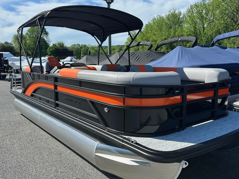 The Image of 2025 Bennington 21 SSR Quad Bench pontoon boat with orange and gray seating, docked outdoors. - 1