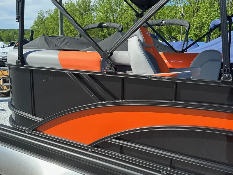Slide: The Image of 2025 Bennington 21 SSR Quad Bench pontoon boat with orange and gray seating. - 24