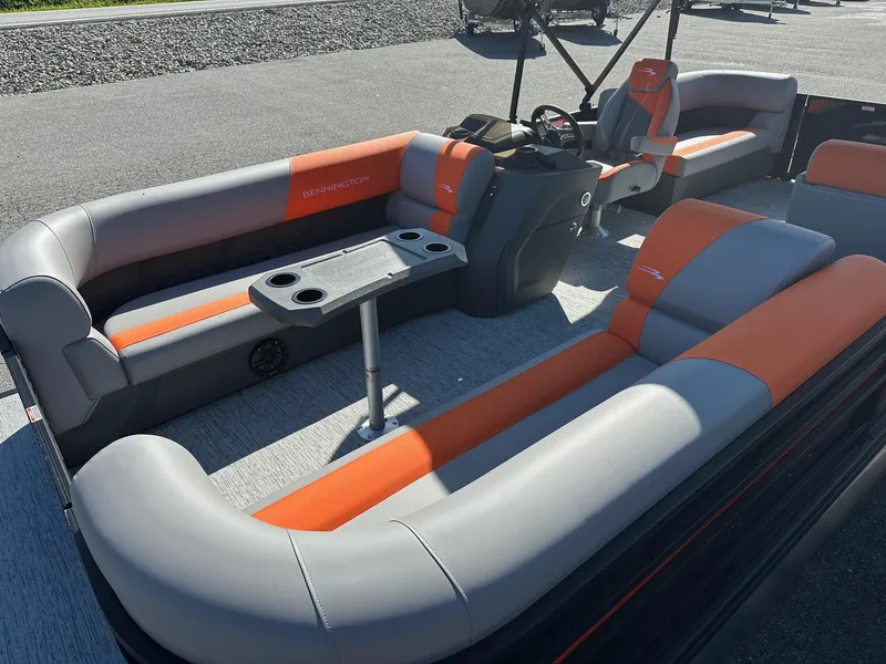 Slide: The Image of 2025 Bennington 21 SSR Quad Bench pontoon boat with orange and gray seating. - 7