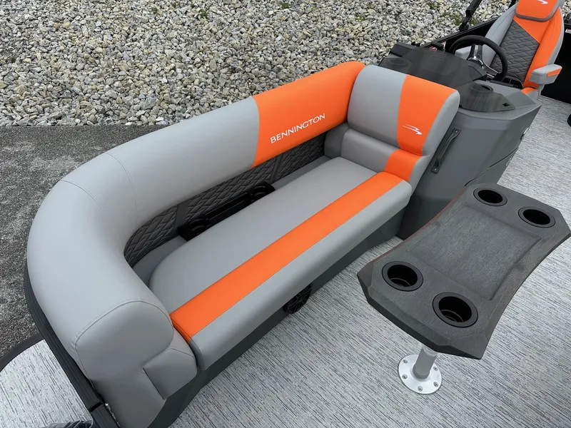 Slide: The Image of 2025 Bennington 22 SSB Swing Back boat interior with orange and gray seating. - 10