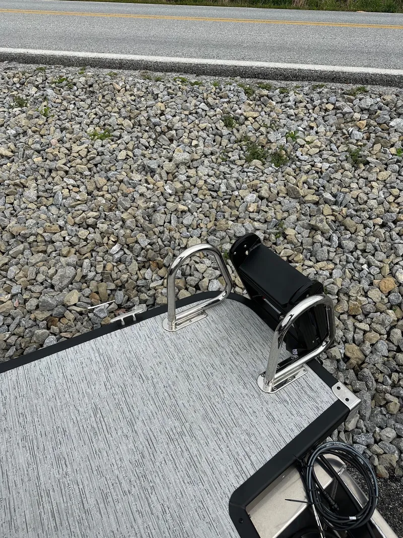 Slide: The Image of 2025 Bennington 22 SSB Swing Back boat deck with ladder on rocky shore. - 32