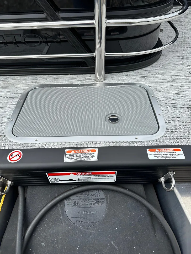 Slide: The Image of 2025 Bennington 22 SSB Swing Back boat deck with safety warnings and railing. - 33