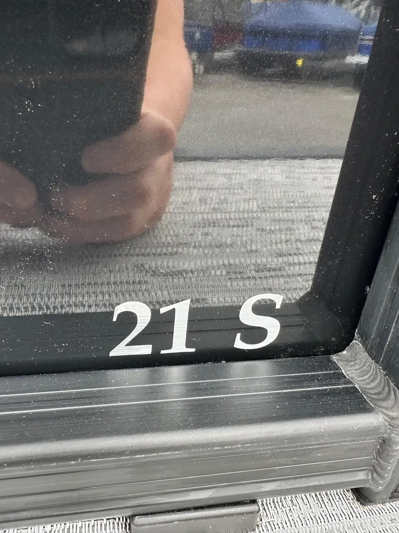 Slide: The Image of Close-up of Bennington 22 SSB Swing Back boat window with '21 S' marking. - 6