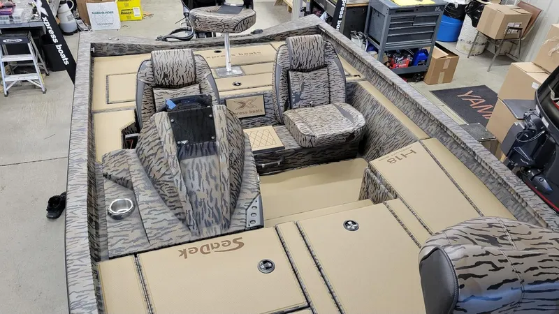 Slide: The Image of 2025 Xpress H18 Bass boat interior with Yamaha Vmax 115, camo seats, and storage compartments. - 15