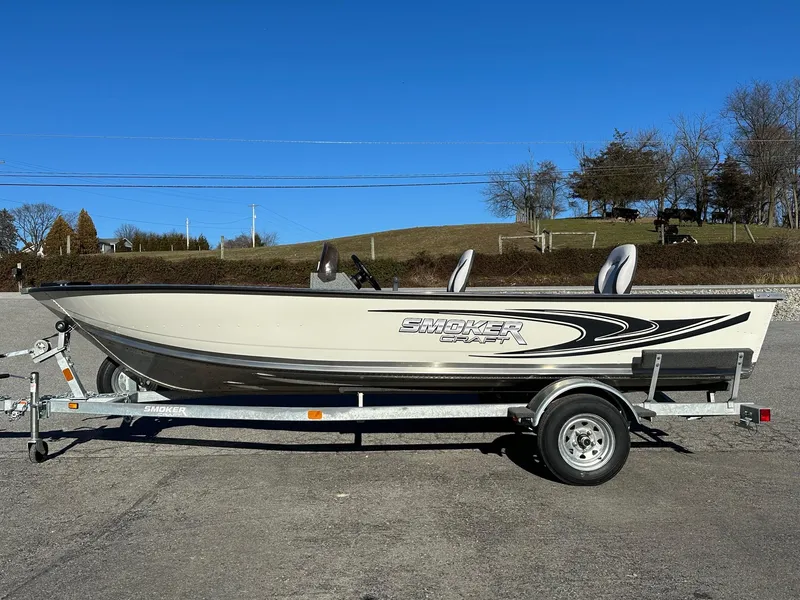 Slide: The Image of 2025 Smoker Craft 16 Angler Patriot SC fishing boat on trailer, clear sky background. - 21