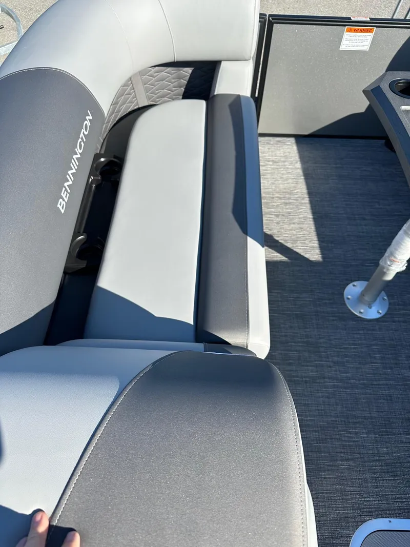 Slide: The Image of 2025 Bennington 20 SSB Tritoon interior seating with gray upholstery and logo. - 12