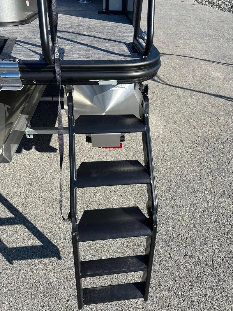 Slide: The Image of 2025 Bennington 20 SSB Tritoon ladder on asphalt, showcasing sturdy design and accessibility. - 5