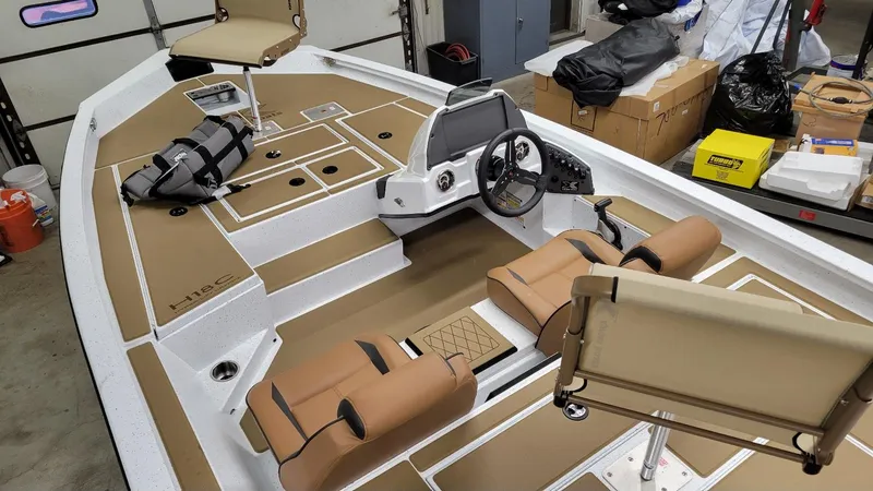 Slide: The Image of 2025 Xpress H18C Crappie boat interior with Yamaha Vmax 115, featuring tan seating and storage. - 12