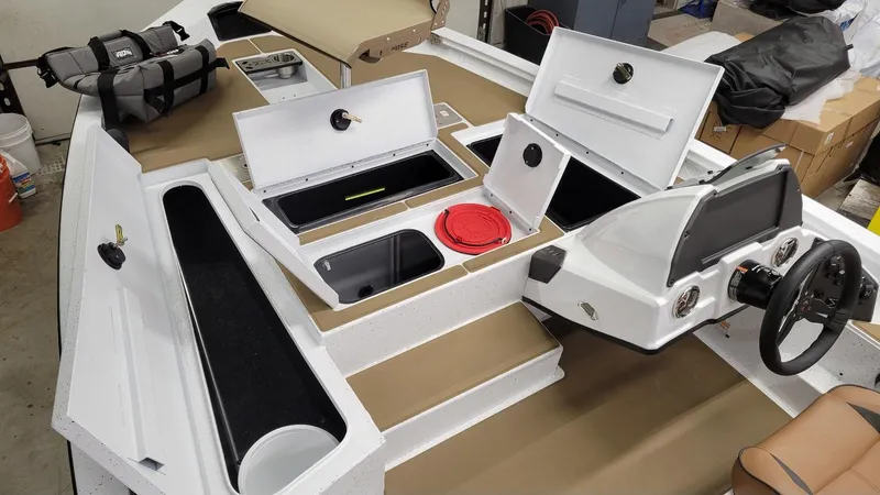 Slide: The Image of 2025 Xpress H18C Crappie boat interior with storage compartments and steering console. - 13