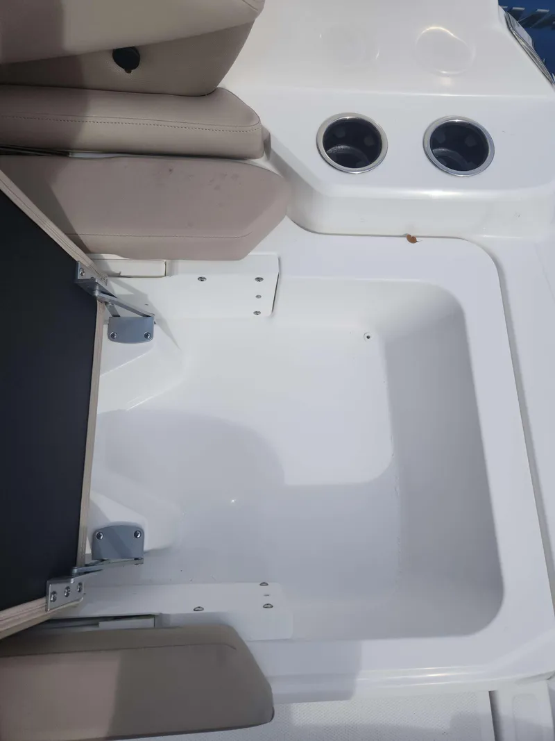 Slide: The Image of 2024 Hurricane 2600 SD boat interior with storage compartment and cup holders. - 3