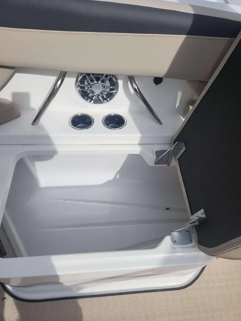 Slide: The Image of Storage compartment and cup holders on a 2024 Hurricane 2600 SD boat. - 5