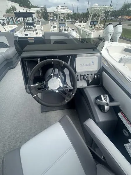 Slide: The Image of 2024 Manitou 22 Cruise Flebrf Stealth boat cockpit with Garmin navigation system. - 4