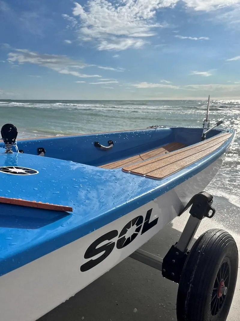 Slide: The Image of 2024 Dinghy Sol Sailboat on a beach with ocean background. - 11