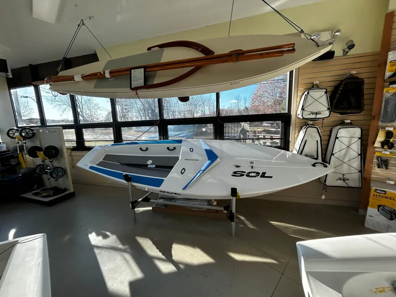 Slide: The Image of 2024 Dinghy Sol Sailboat displayed in a showroom with accessories. - 3