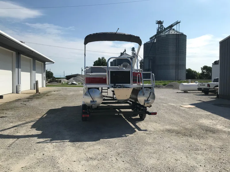 Slide: The Image of 2024 Avalon VTX Cruise pontoon boat parked outdoors near industrial buildings. - 12