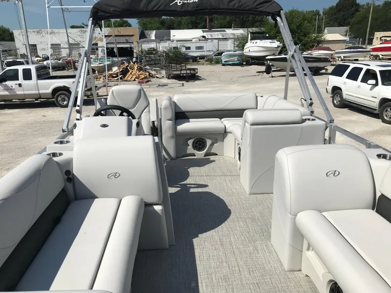 Slide: The Image of 2024 Avalon VTX Cruise pontoon boat on trailer in industrial setting. - 13