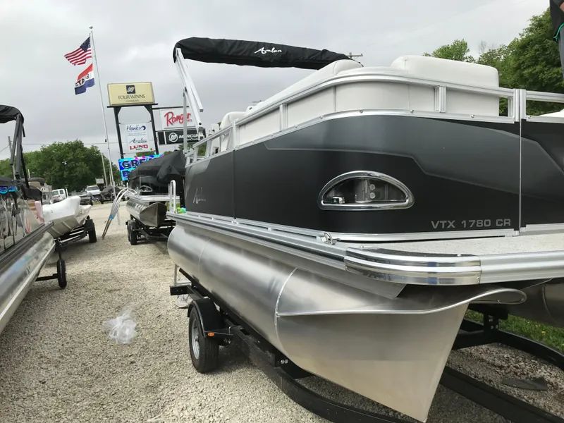 Slide: The Image of 2024 Avalon VTX Cruise pontoon boat on trailer in outdoor lot. - 3