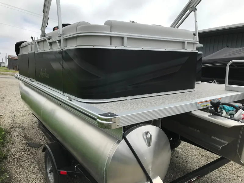 Slide: The Image of 2024 Avalon VTX Cruise pontoon boat rear view with storage compartment and ladder. - 5