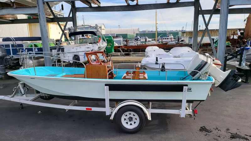 The Image of 1968 Boston Whaler 16 Sakonnet boat on a trailer at a marina. - 0