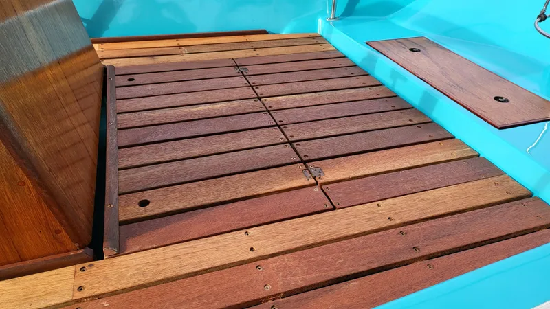 Slide: The Image of Wooden deck of a 1968 Boston Whaler 16 Sakonnet boat with blue accents. - 10