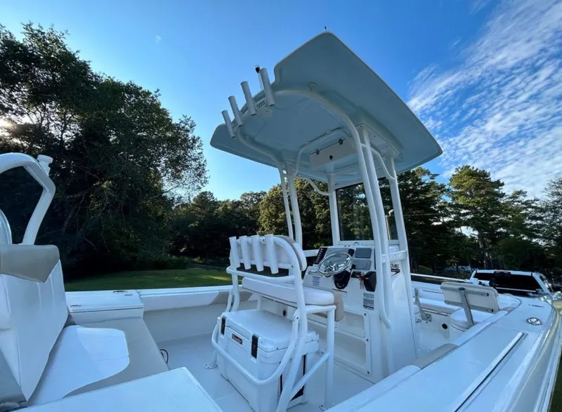 Slide: The Image of 2019 Robalo 246 Cayman boat with T-top and seating, docked outdoors. - 10