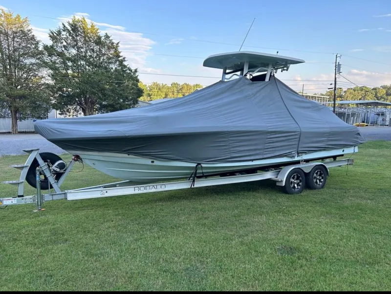 Slide: The Image of 2019 Robalo 246 Cayman boat on a trailer with a protective cover. - 12