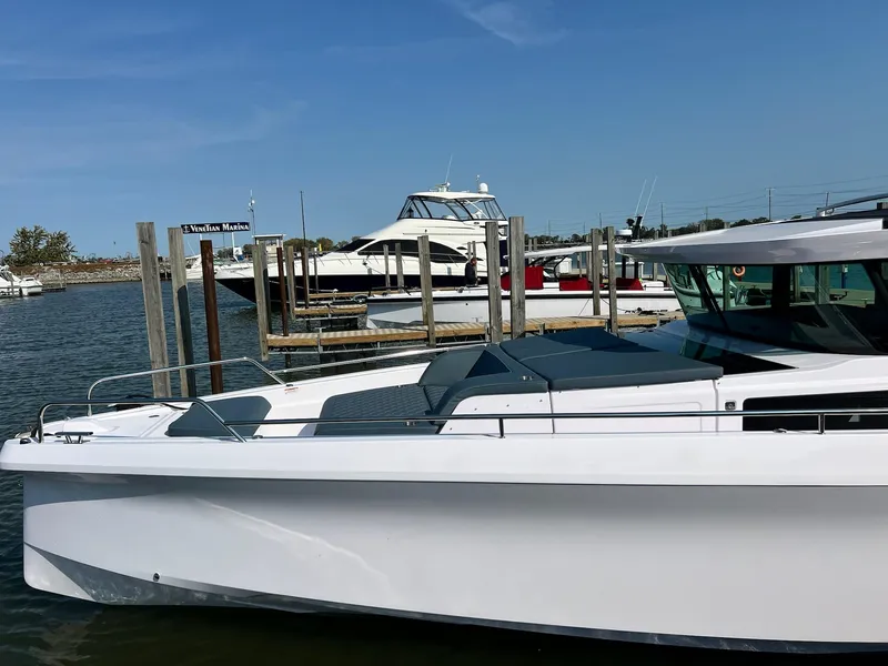 Slide: The Image of 2024 Axopar 45 XC Cross Cabin boat docked at marina. - 2