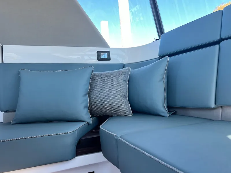 Slide: The Image of 2024 Axopar 45 XC Cross Cabin interior with blue cushioned seating and pillows. - 22