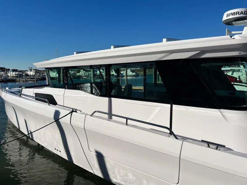 Slide: The Image of 2024 Axopar 45 XC Cross Cabin boat docked in marina. - 3