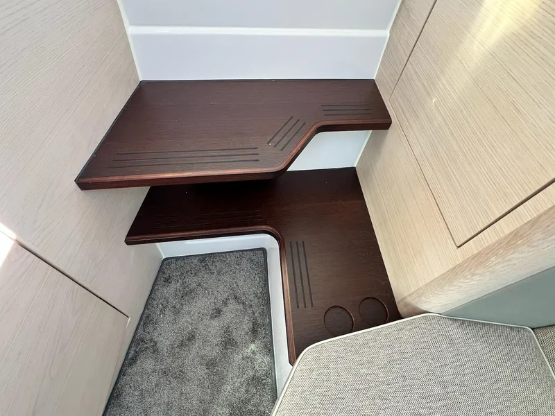 Slide: The Image of 2024 Axopar 45 XC Cross Cabin interior with wooden steps and carpeted flooring. - 31