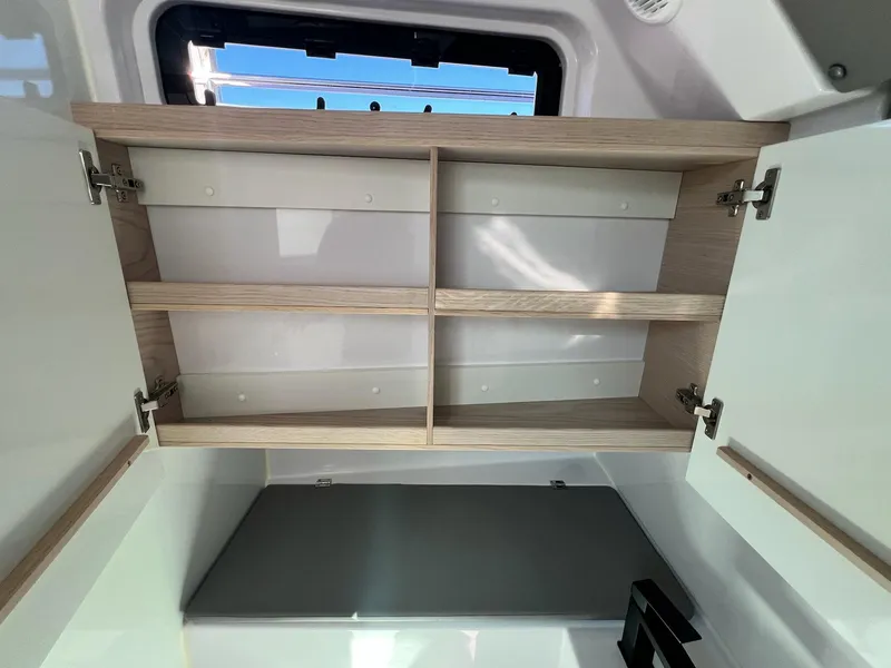 Slide: The Image of Open cabinet inside 2024 Axopar 45 XC Cross Cabin boat, showcasing storage space. - 38