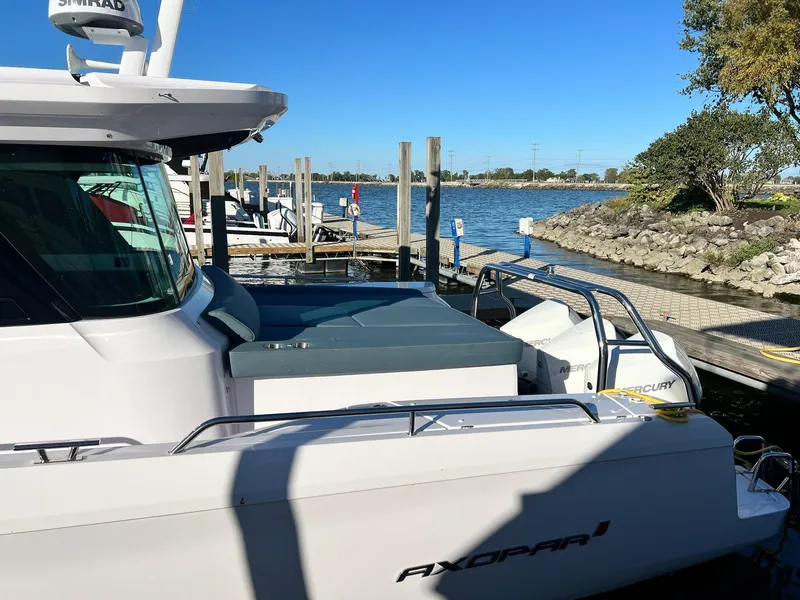 Slide: The Image of 2024 Axopar 45 XC Cross Cabin docked by a scenic waterfront. - 4
