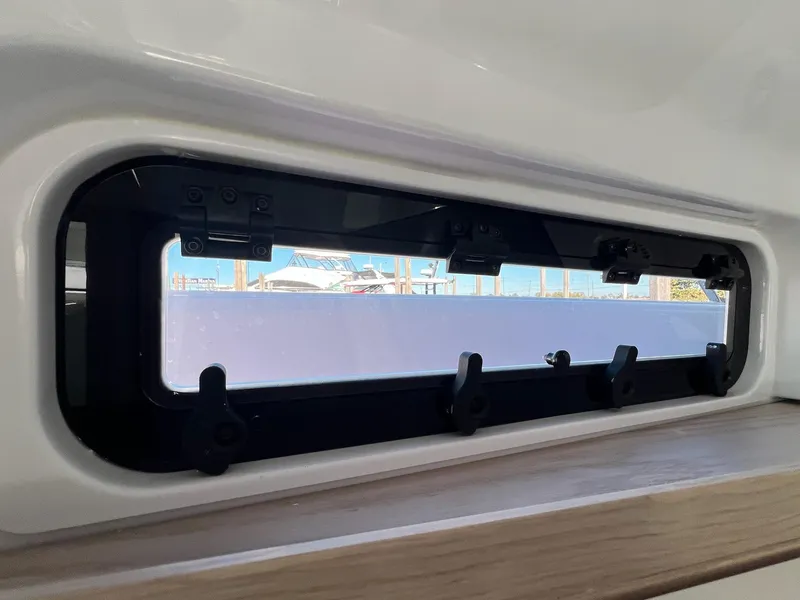 Slide: The Image of 2024 Axopar 45 XC Cross Cabin window view with sleek design and marina backdrop. - 40