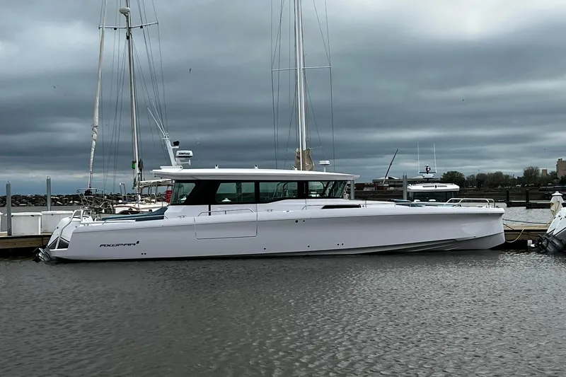 Slide: The Image of 2024 Axopar 45 XC Cross Cabin boat docked in a marina under cloudy skies. - 43