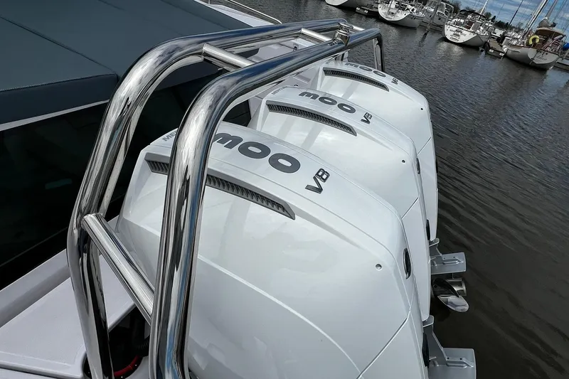 Slide: The Image of Triple outboard engines on 2024 Axopar 45 XC Cross Cabin boat, docked in marina. - 44
